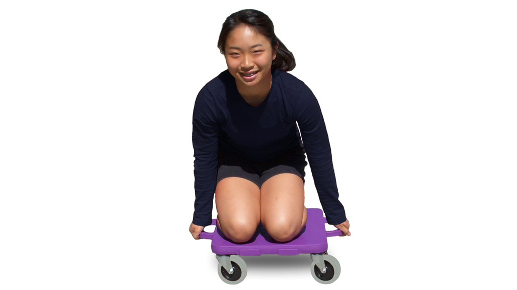 young girl riding a connect-a-scooter gym scooter, on her knees