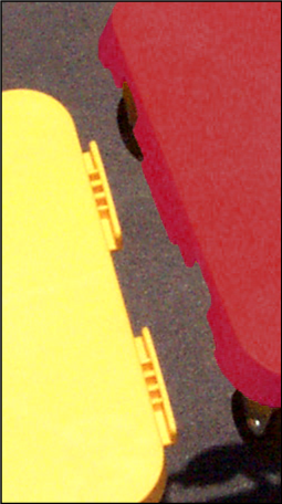 Close up of a red plastic gym scooter about to be connected to a yellow plastic gym scooter using a patented tongue and groove built-in connecting feature.